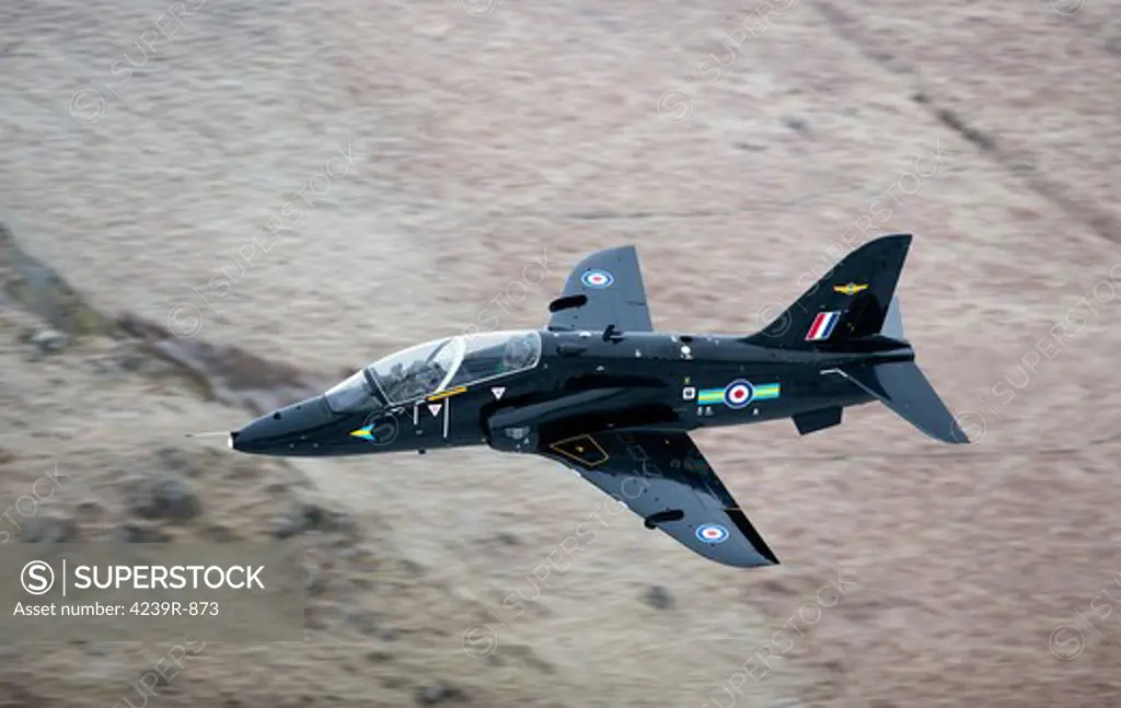 A Hawk jet trainer aircraft of the Royal Air Force low flying over North Wales