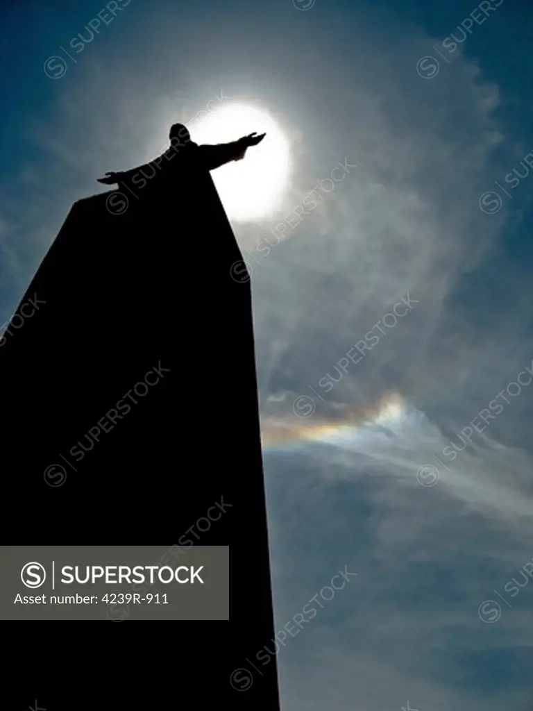 Almada, Portugal - A silhouette of the Portuguese statue of Christ the King with visible ice halos