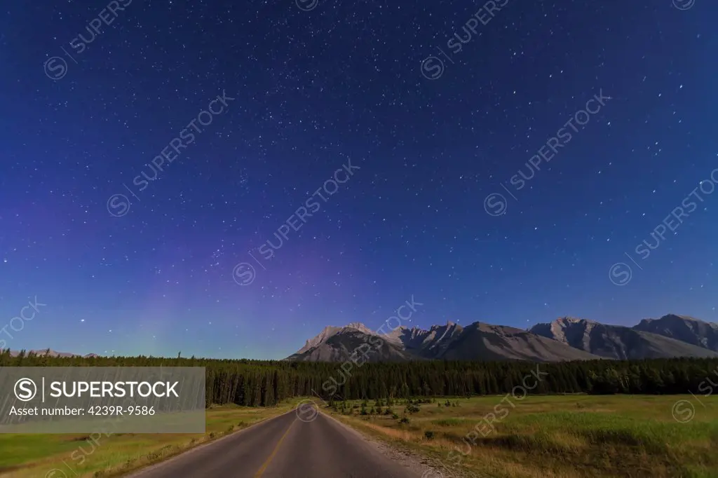 July 29, 2012 - The northern autumn constellations of Andromeda, Cassiopeia, Perseus, and Pegasus rising over a road in Banff National Park, Alberta, Canada. Moonlight from a waxing gibbous moon (off camera) provides the illumination. A faint aurora is at left.