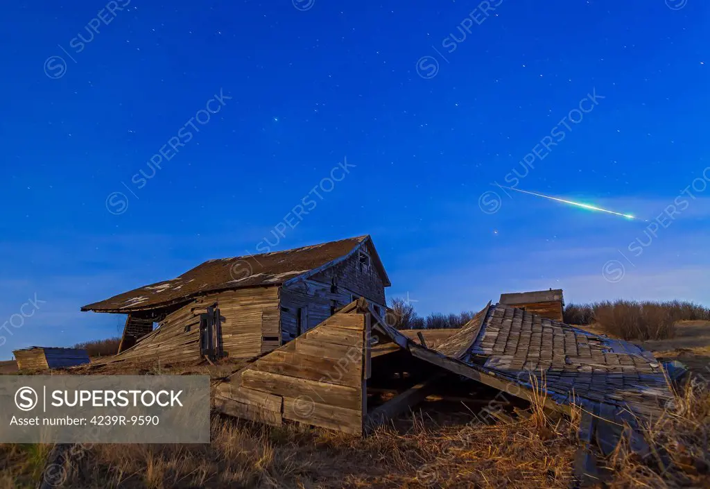 April 25, 2013 - A bright bolide meteor breaking up as it enters the atmosphere under the light of a full moon.