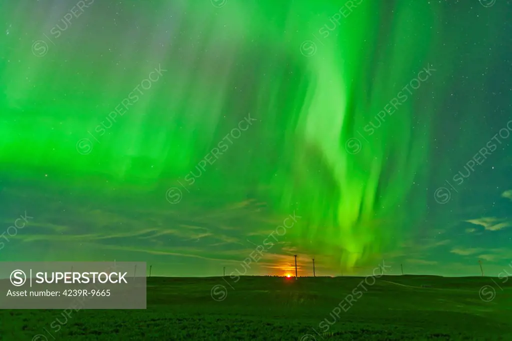 June 29, 2013 - The northern lights as seen from the Wintering Hills Wind Farm near Drumheller, Alberta, Canada. The moon is just rising as the display is reaching a peak in intensity.