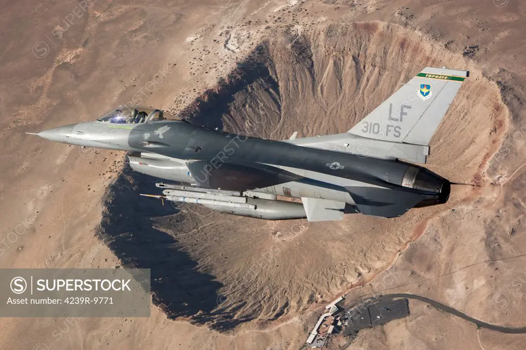 F-16C Fighting Falcon flying above Arizona's Meteor Crater. The F-16C Fighting Falcon is the flagship of the 310th Fighter Squadron Top Hats.