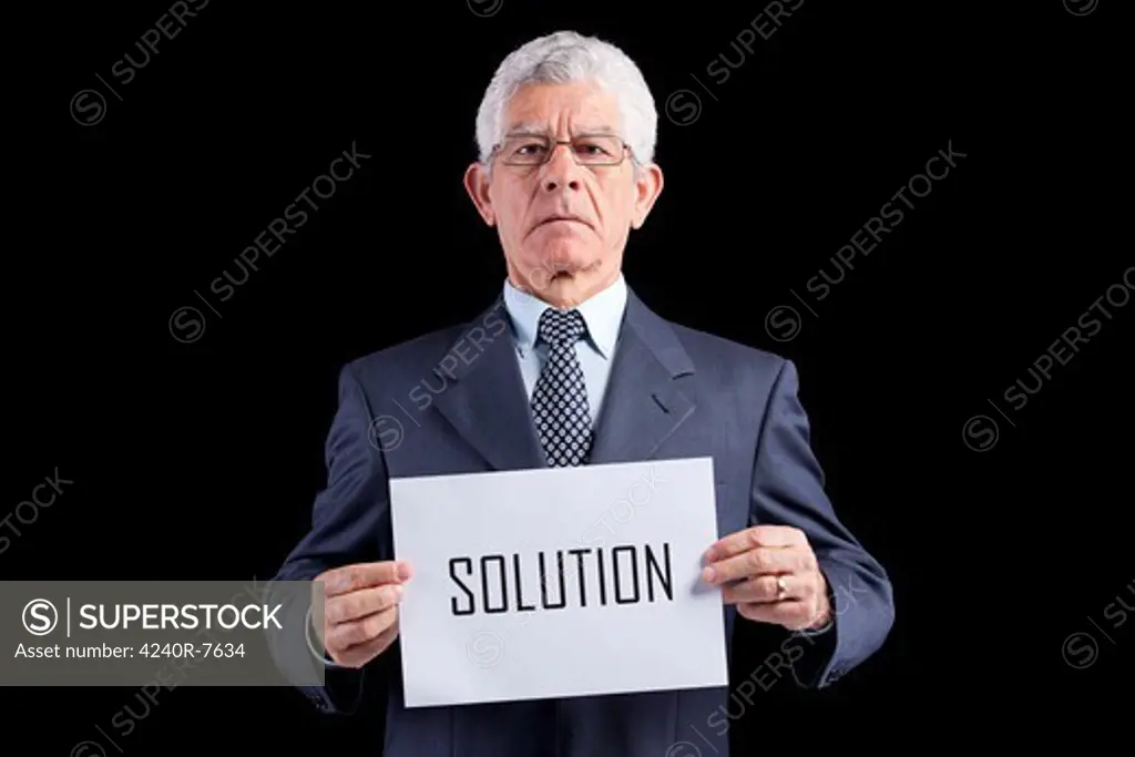 Senior Businessman Holding A Paper With The Solution Word (Isolated On Black)