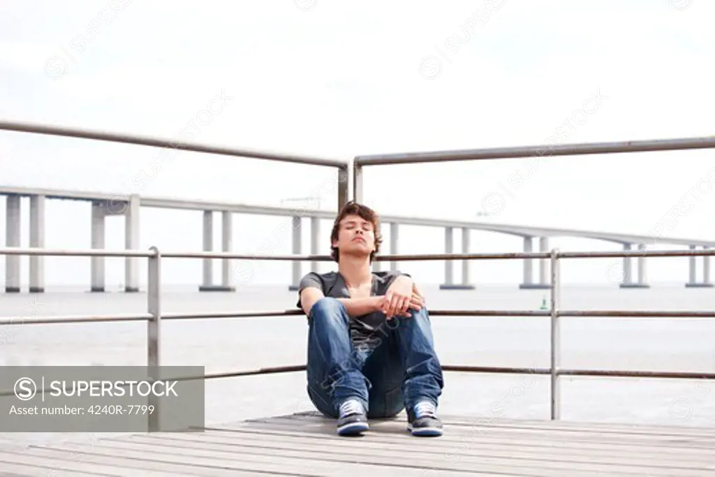 Handsome Teenager With A Sad Face Sited Next To The River