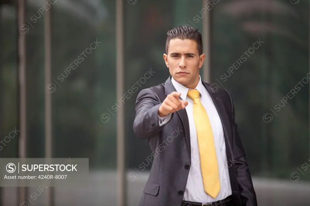 Businessman Next To His Office Pointing To You