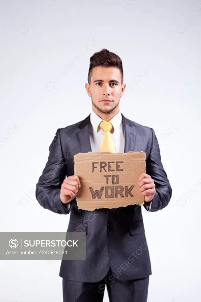 Young Businessman Holding A Piece Of Cardboard Saying Free To Work