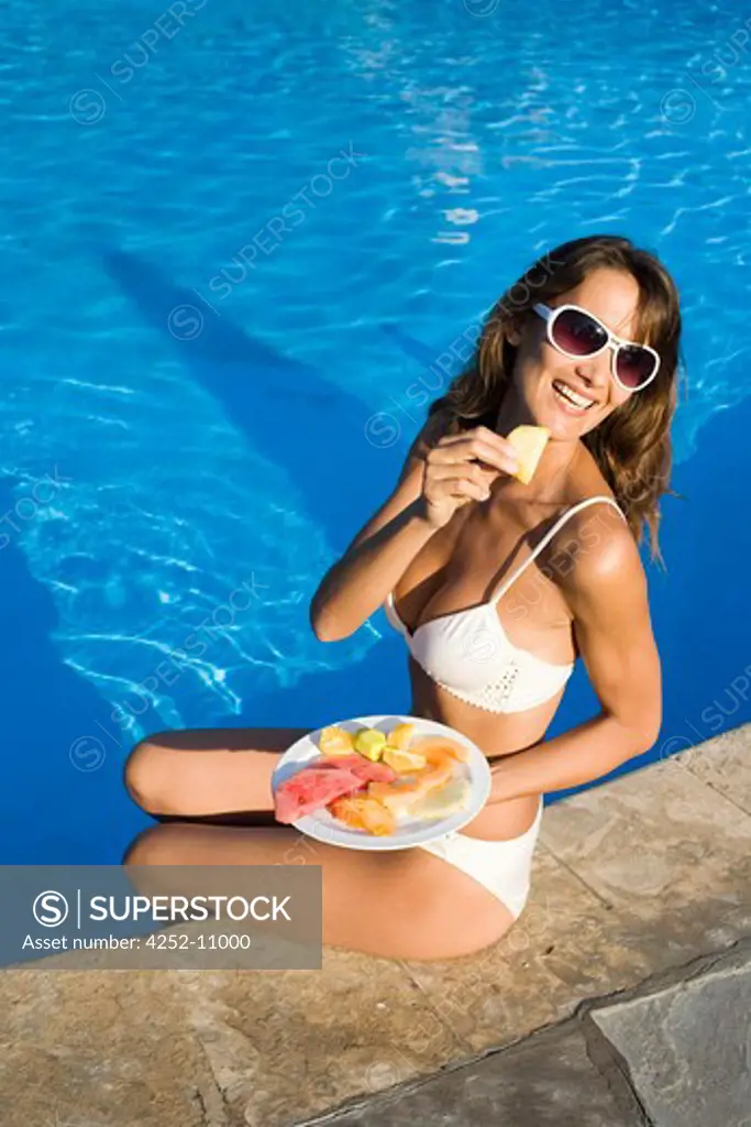 Woman swimming pool fruits.