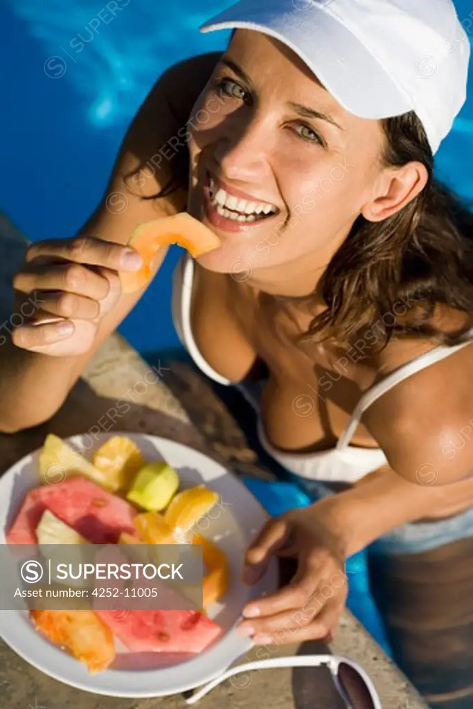 Woman swimming pool fruits.