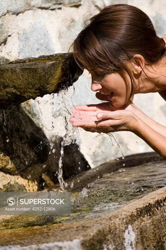 Woman drink fountain.