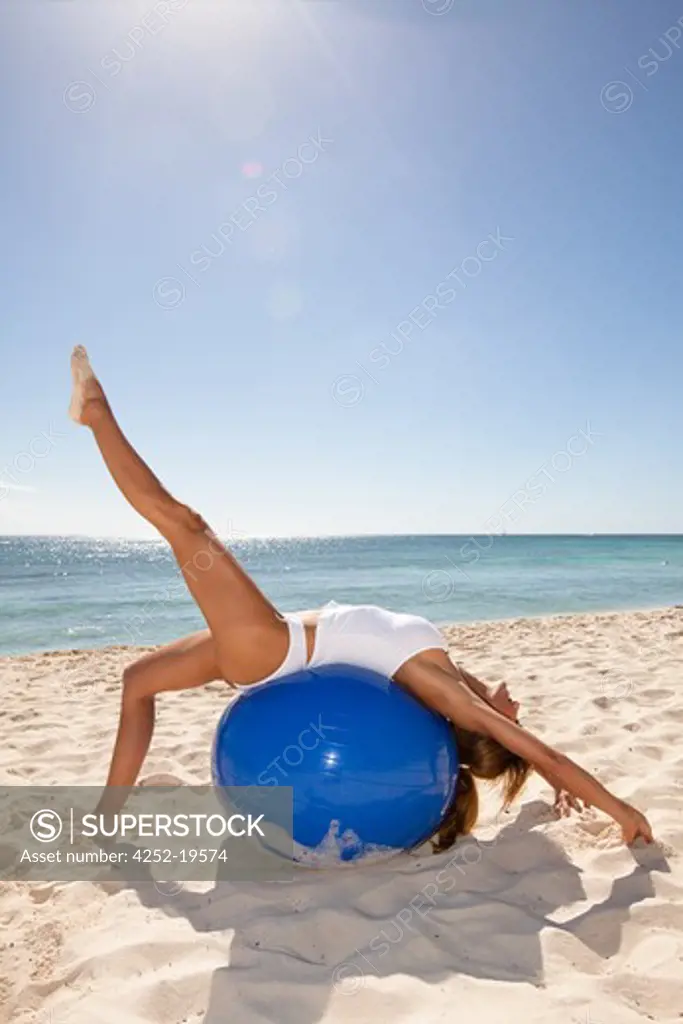Woman streching ball beach
