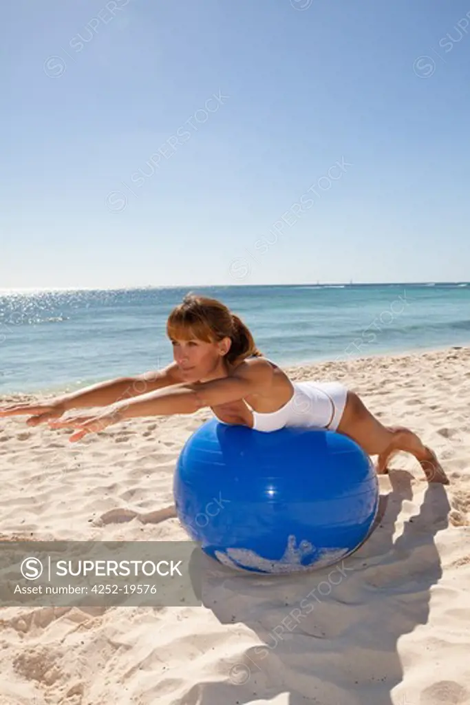 Woman streching ball beach