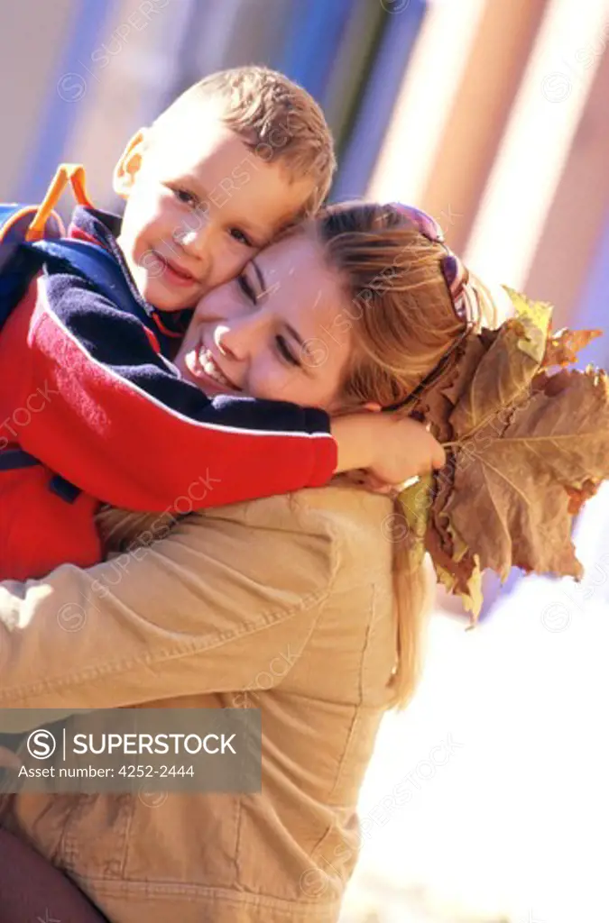 family outside child woman going to school boy schoolbag smiling complicity school