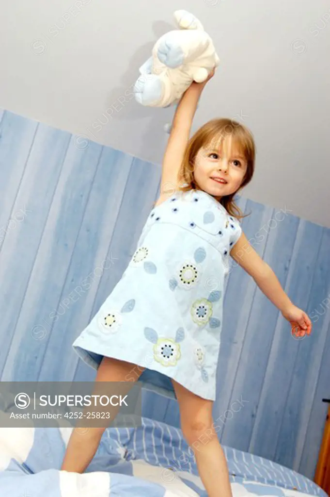 Little girl standing on bed
