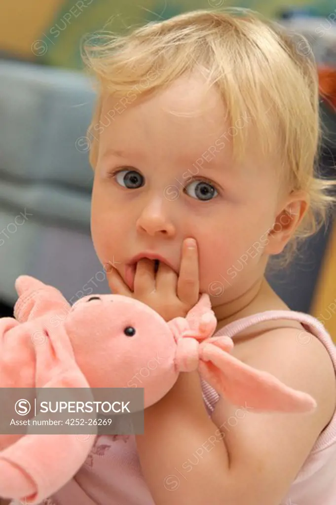 Little girl with fluffy sucking her fingers