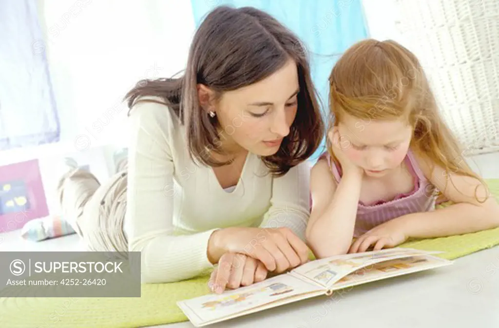 Young woman and little girl looking at book
