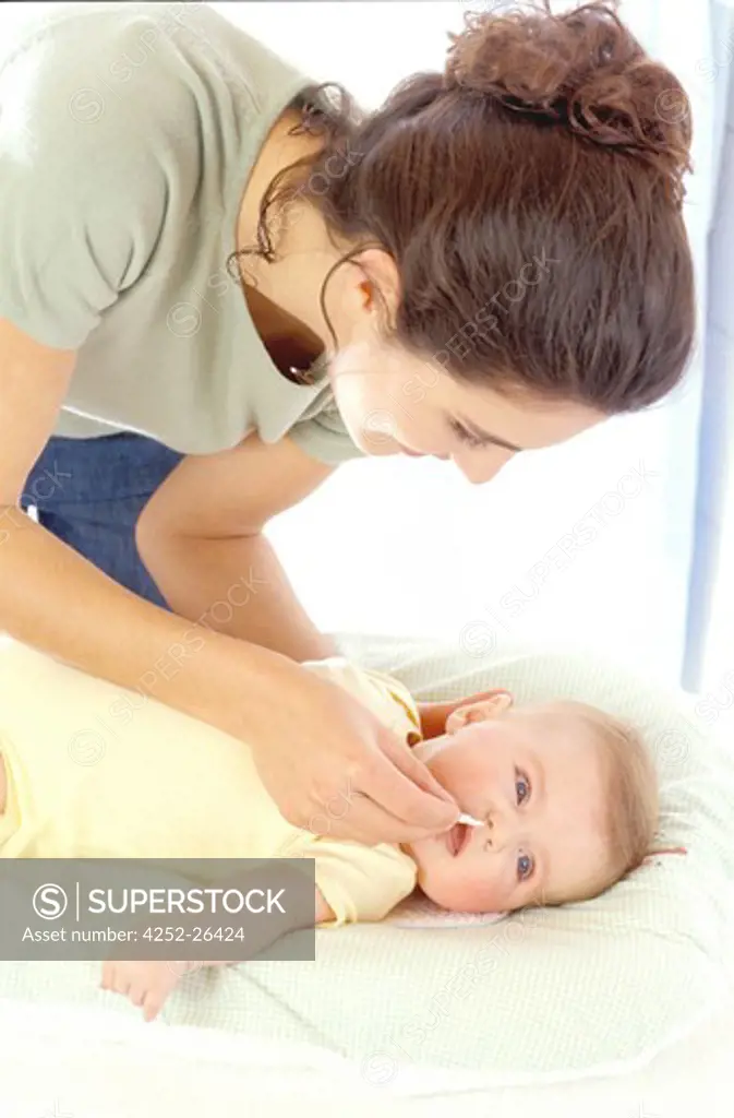 Woman cleaning nose of baby