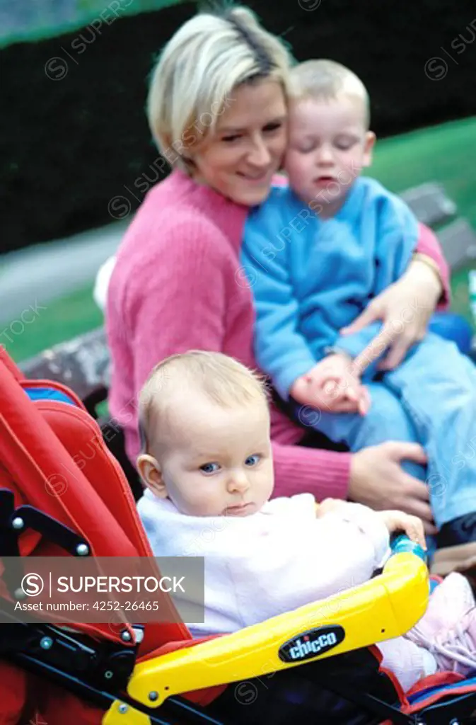 Mother and chidren sitting on bench in a park