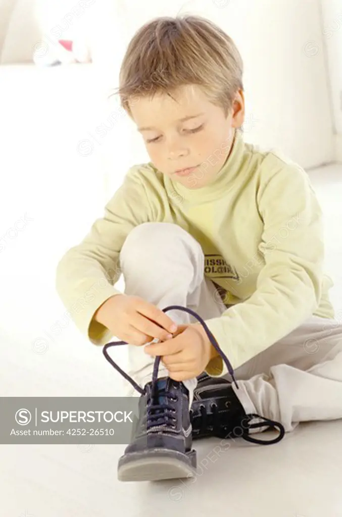 Little boy tying his shoelaces