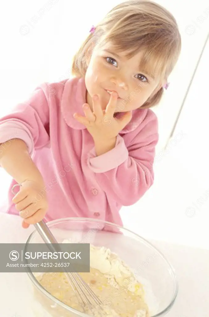 Little girl preparing a pancake batter