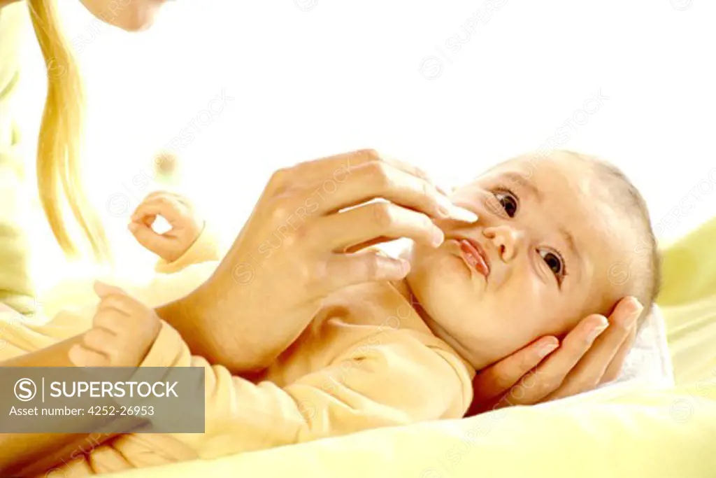 Woman cleaning baby's nose