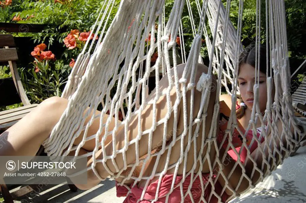 Teenager reading in a hammock
