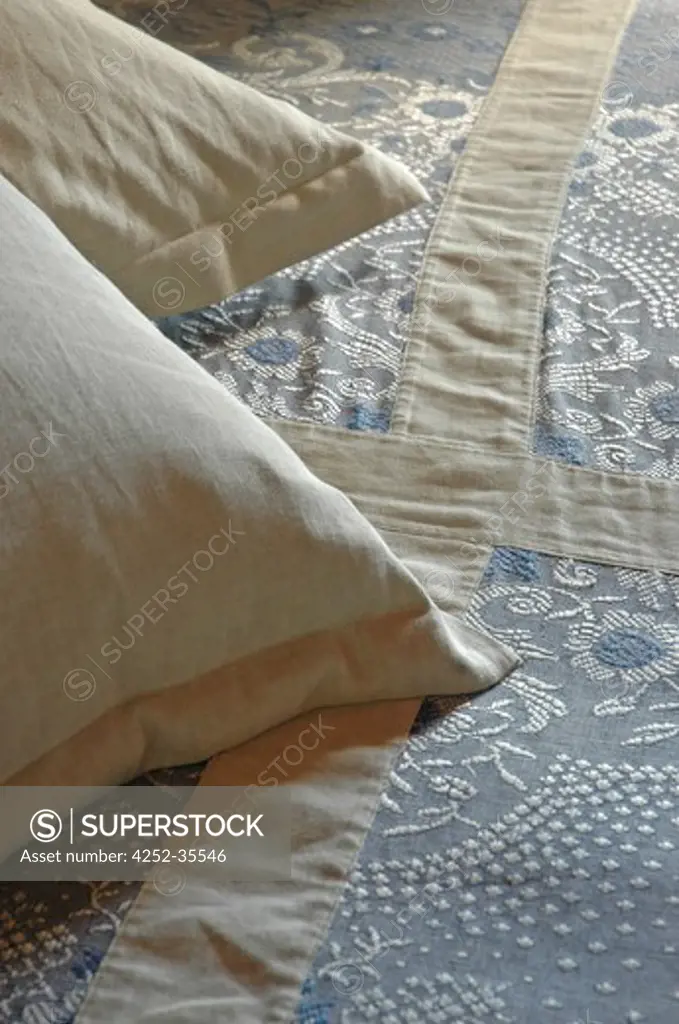Detail of embroidered blue coverlet with cushions