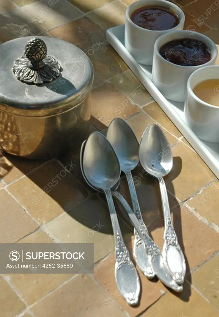 Silver spoons and sugar bowl on an outside table