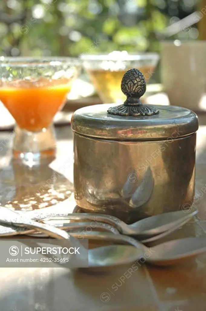 Silver spoons and sugar bowl on an outside table
