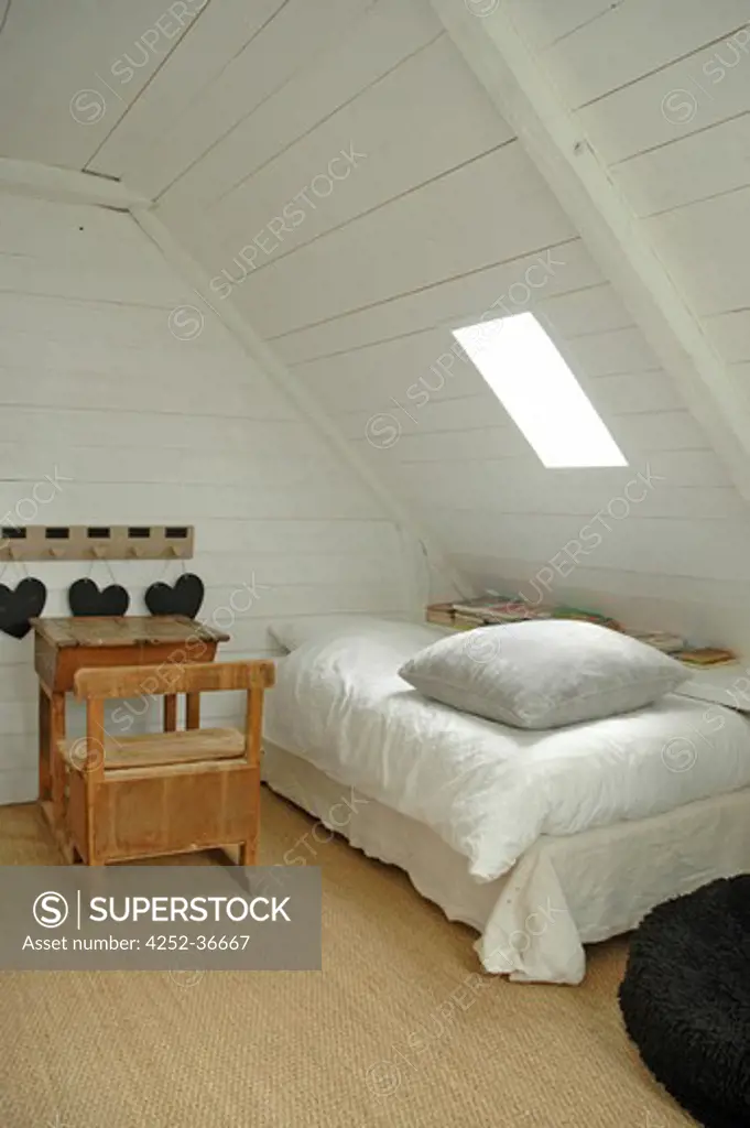 Child attic white bedroom with an old school desk and a single bed