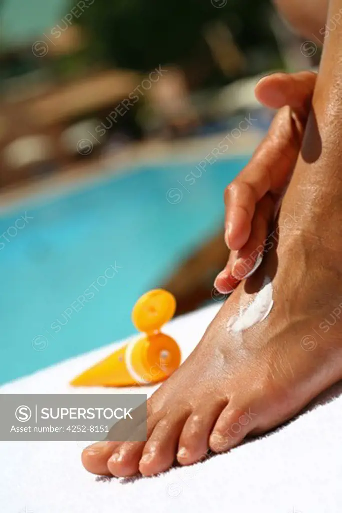 Woman sunscreen cream and foot