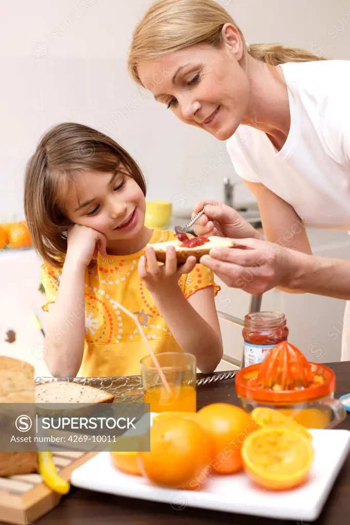 Child having breakfast or snack with her mother.