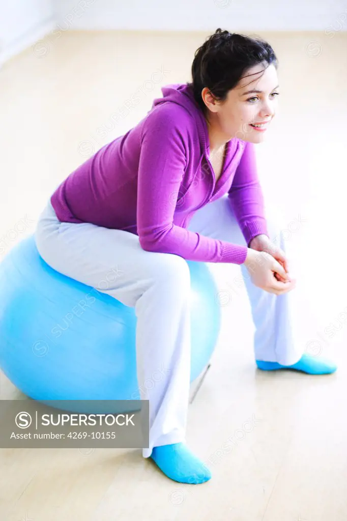 Pregnant woman practising gymnastic exercise.