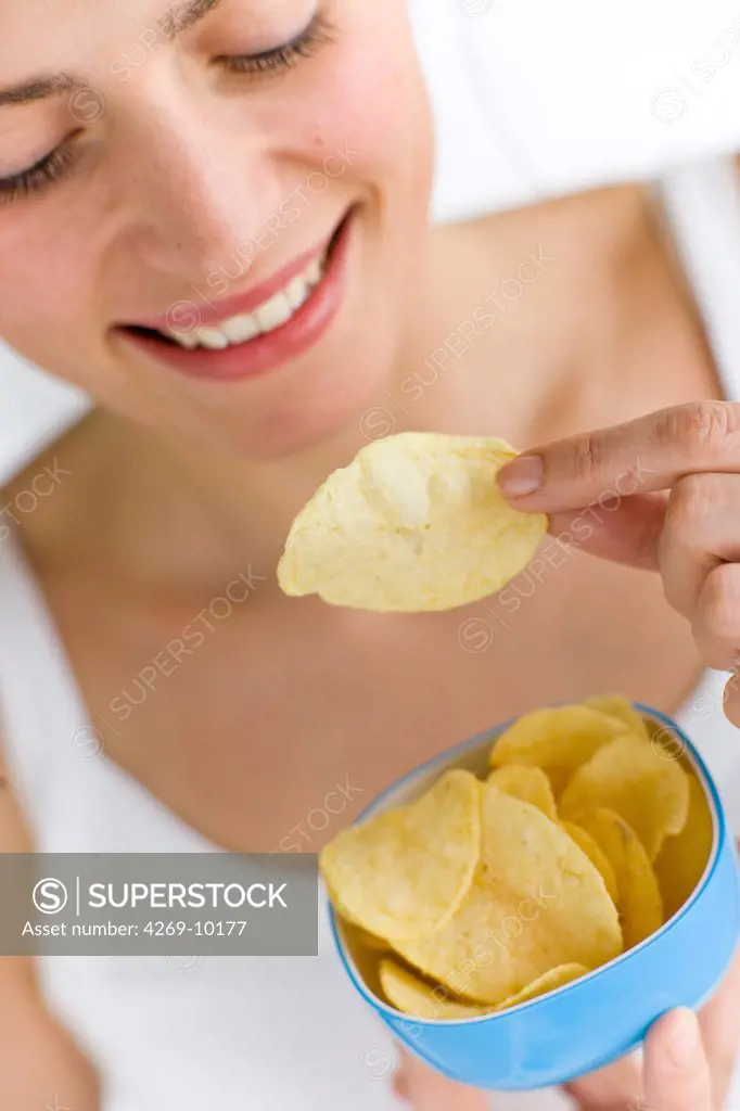 Woman eating potato chips.
