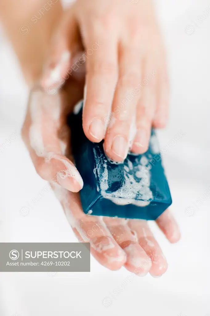 Woman washing hands with bar of soap.