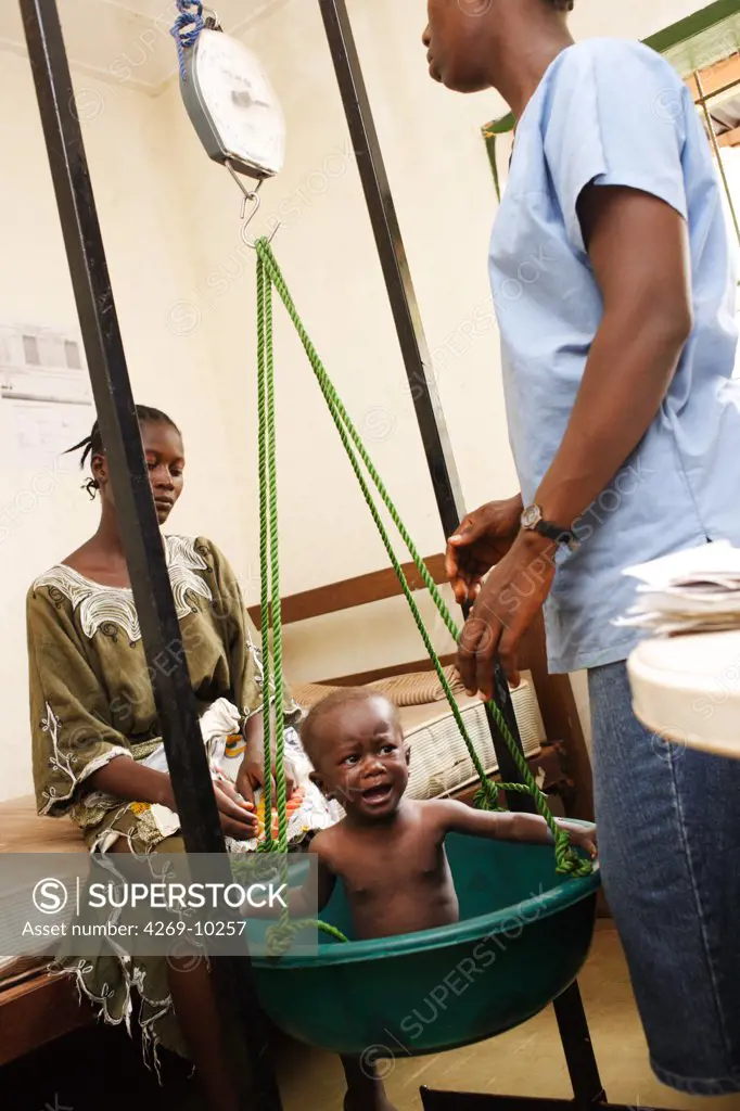 Undernourished children being weighed. Program of ambulatory treatment of malnutrition implemented by a local non-governmental organisation and Action contre la Faim (ACF), an international non-governmental organisation (Action against Hunger). Pipeline hospital, Monrovia, Liberia.