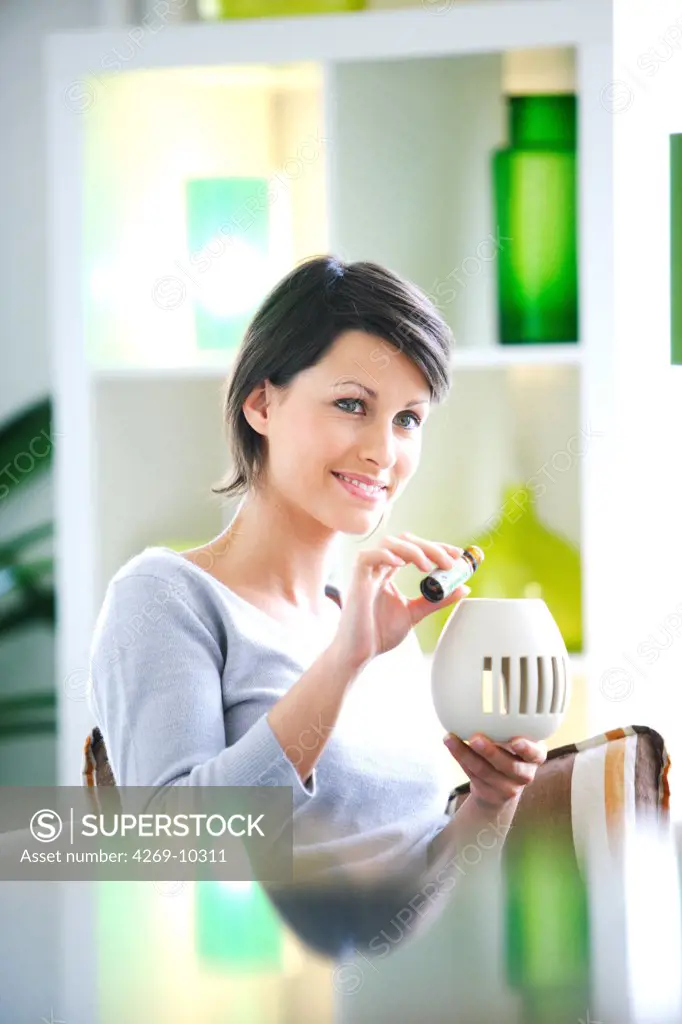 Woman putting essential oils in diffuser.