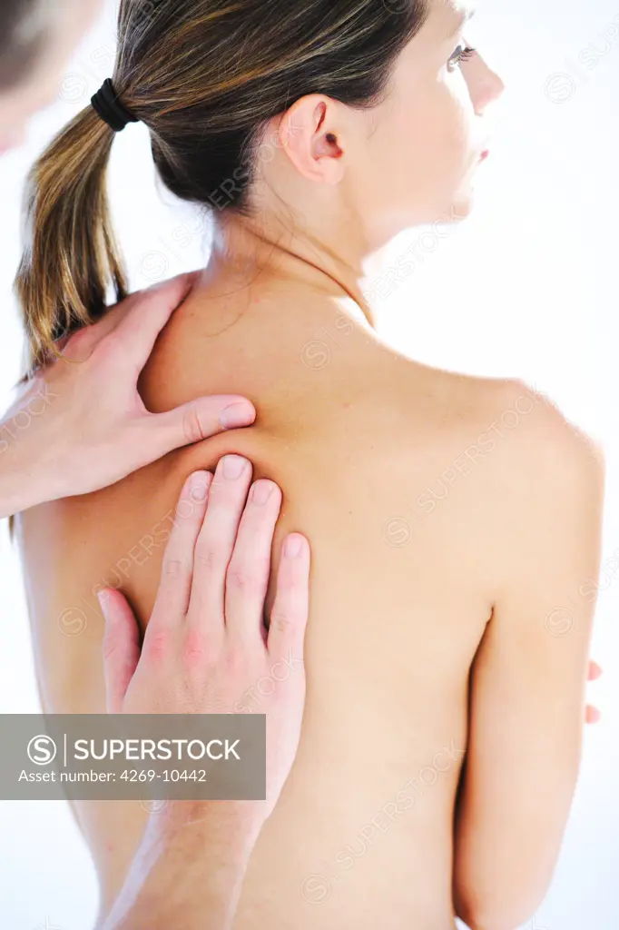 Woman's back being manipulated by osteopath.