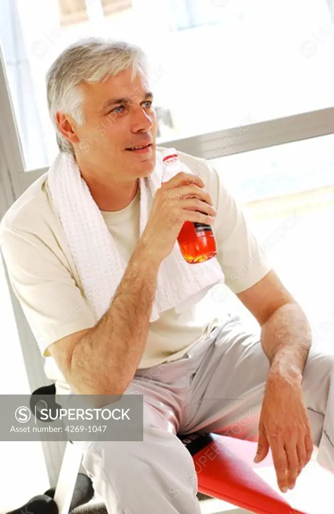 Man drinking energy drink while practising physical activity.