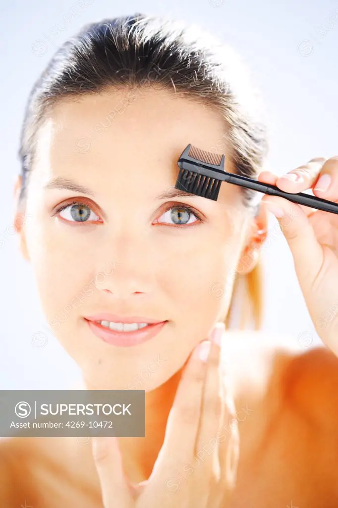 Woman using an eyebrow brush.