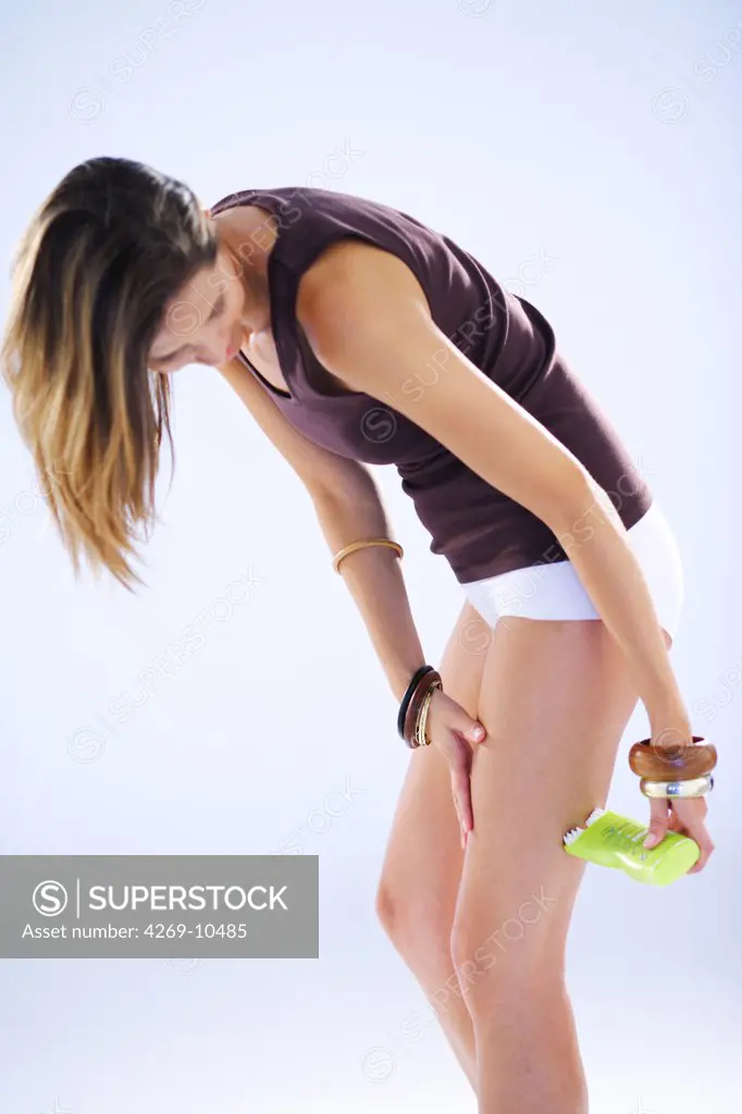 Woman applying slimming cream.