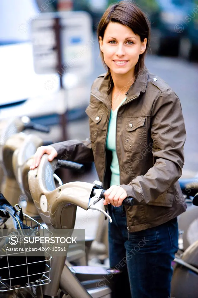 Woman using a Velib bike in a hire station in Paris. Vélib is a public bicycle rental service launched on July 15, 2007 in Paris, France.