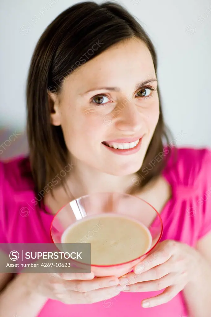 Woman taking low calorie and hyperproteinated meal substitute for slimming diet.