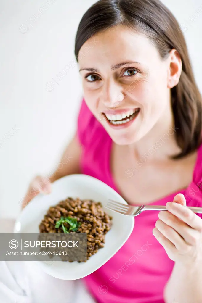 Woman eating lentils.