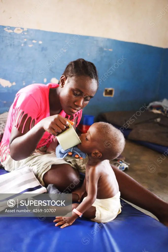 Mother giving her child suffering from malnutrition therapeutic milk in a Therapeutic Feeding Center in Monrovia, Liberia, implemented by Action contre la Faim (ACF), an international non-governmental organisation (Action against Hunger).