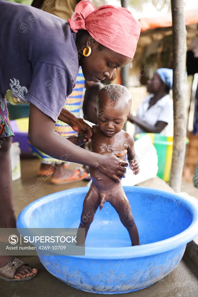 Mother washing her child suffering from malnutrition in a Therapeutic Feeding Center in Monrovia, Liberia, implemented by Action contre la Faim (ACF), an international non-governmental organisation (Action against Hunger).
