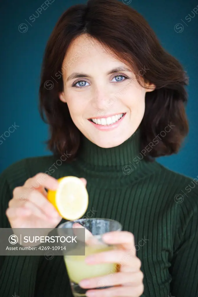 Woman drinking freshly squeezed lemon juice.