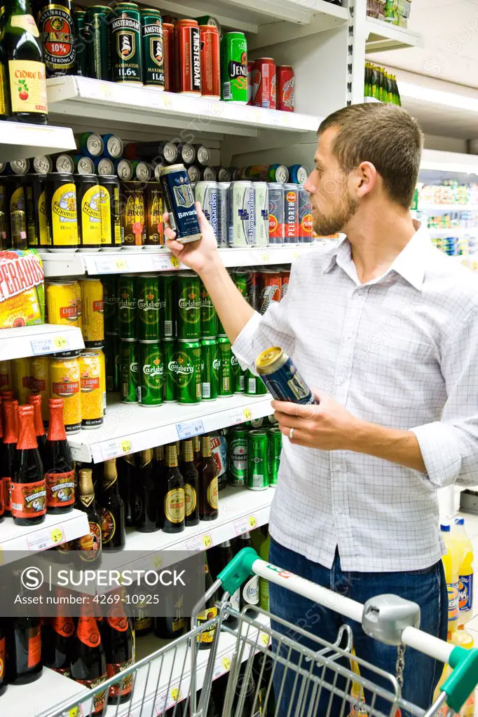 Man shopping in the liquors section in supermarket.