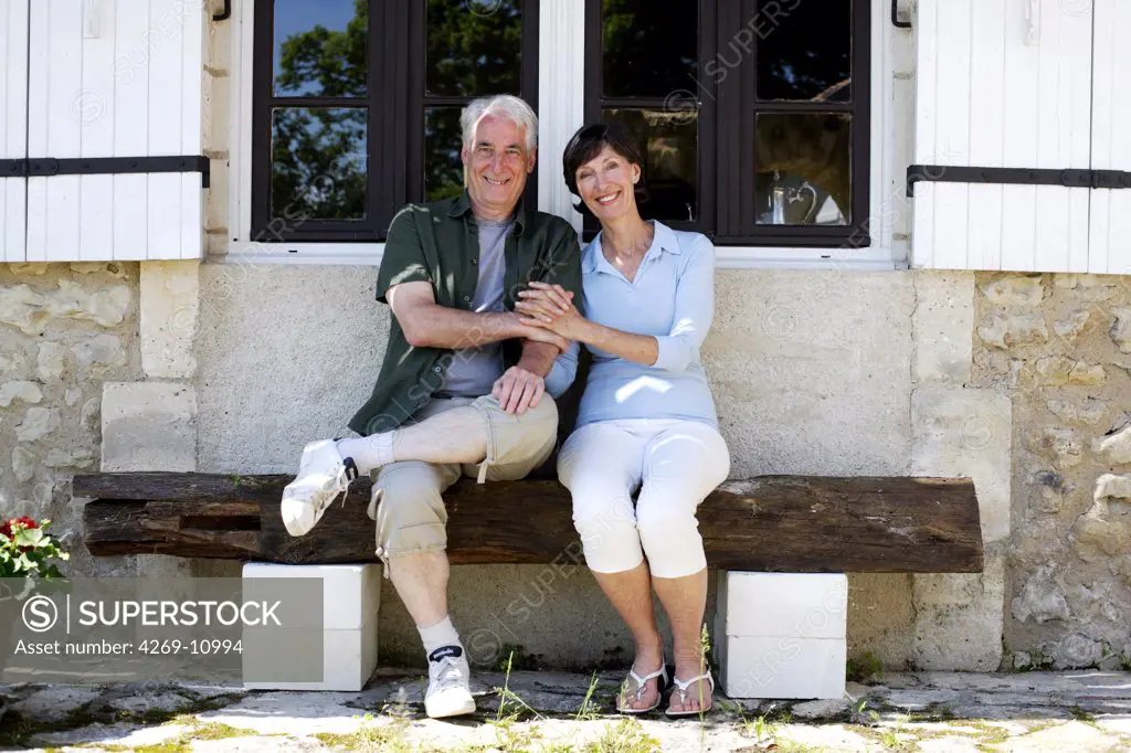 Senior couple sitting on bench.