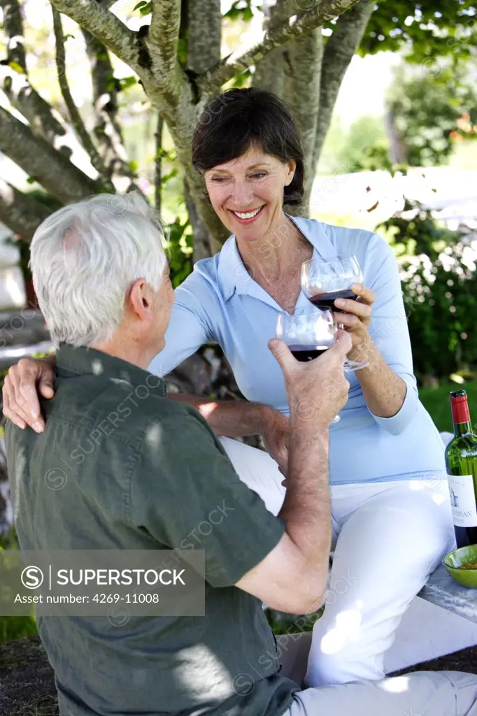 Senior couple drinking glass of red wine.