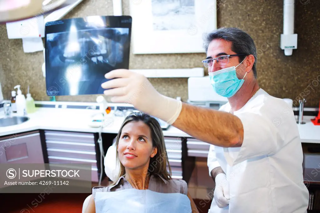 Dentist showing a patient panoramic dental X-ray.